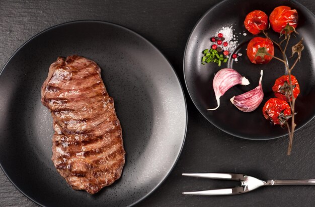 Entrecote de chuletón a la parrilla sobre fondo de piedra negra