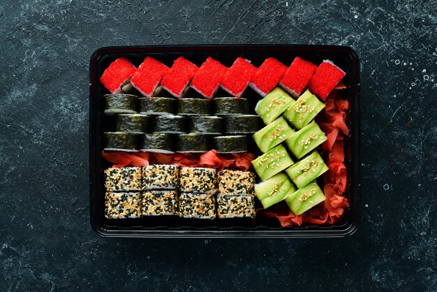 Entrega de alimentos rollos de sushi Conjunto de sushi en una caja de plástico Cocina tradicional japonesa Vista superior Estilo rústico
