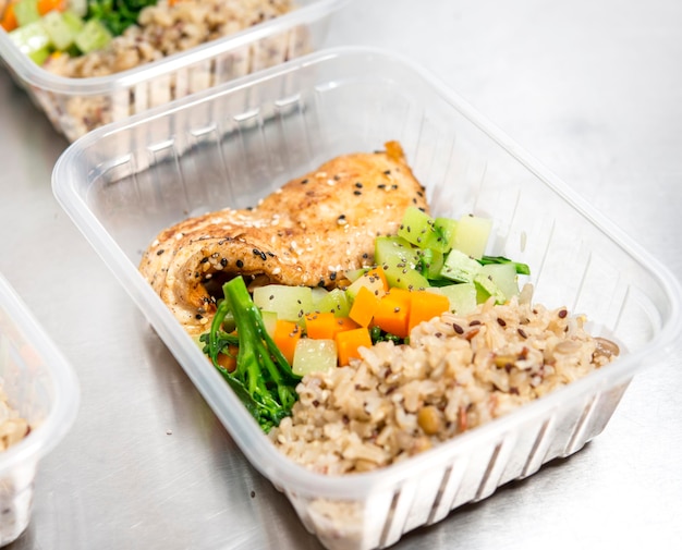 Entrega de comida, caja de comida sana con pollo a la plancha, arroz integral y ensalada.