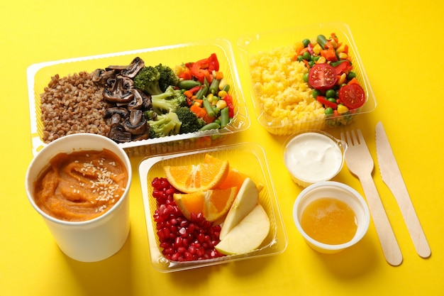 Entrega de comida. Comida en cajas de comida para llevar en la pared amarilla