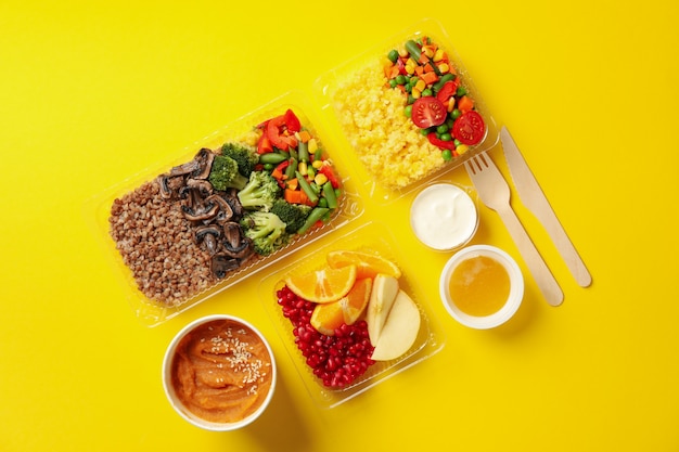 Entrega de comida. Comida en cajas de comida para llevar sobre fondo amarillo