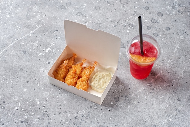 Entrega de comida, comida para llevar con camarones en tempura y refresco, limonada en vaso plástico, envases de papel con camarones y salsa. maqueta de menú y logo