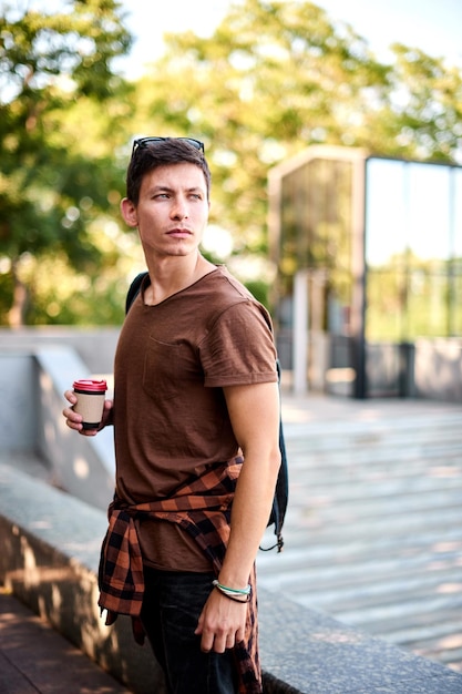 Entrega de comida para llevar hombre taza de café para ir a descansar relajarse en el parque de la ciudad bajar callejón sol césped