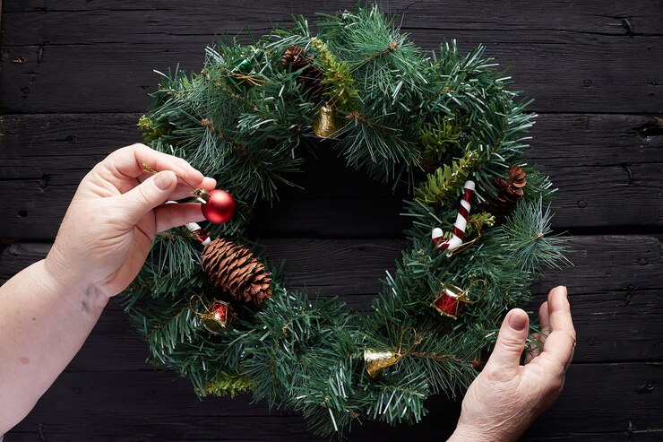 Foto entrega corona de navidad sobre fondo de madera