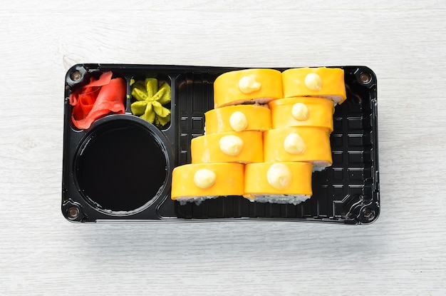 Entrega de comida japonesa Sushi rolls com queijo wasabi e molho de soja em uma caixa plástica Vista superior