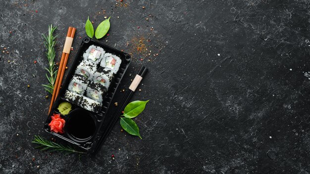 Foto entrega de comida rolos de sushi com caviar e caranguejo molho de soja wasabi vista superior espaço livre para o seu texto cozinha asiática