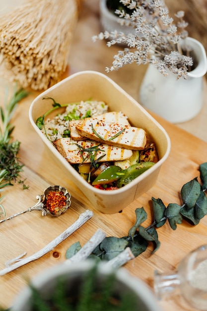 entrega de comida vegana rica em vitaminas com colorau tofu cuscuz e cogumelos em caixa ecológica