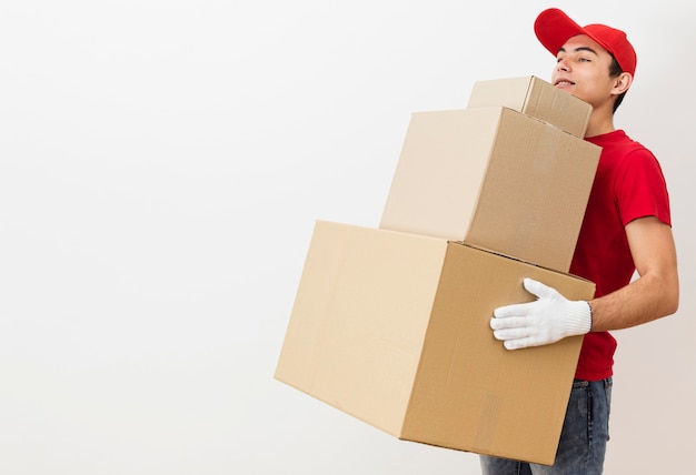 Foto entrega de cópia-espaço masculino carregando pilha de pacotes