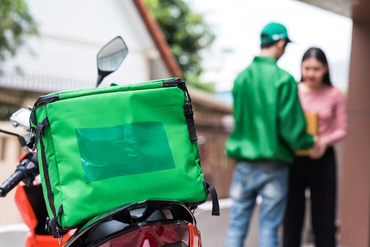 Foto entrega de motocicleta com comida isotérmica caixa de caixa verde em casa entrega de comida na cidade
