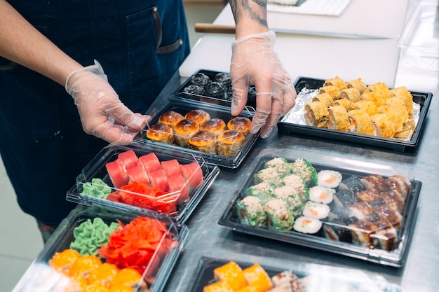 Entrega de sushi. Muitas variedades de sushi em uma caixa de plástico são preparadas para entrega.