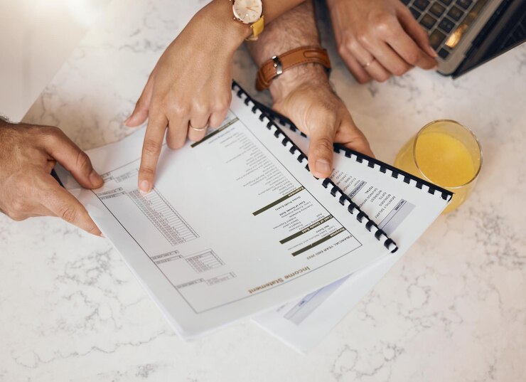 Foto entrega documentos e um casal na cozinha para fazer um orçamento para financiar investimentos ou poupanças em uma casa de cima seguro de papel ou planejamento com marido e mulher lendo informações para contabilidade