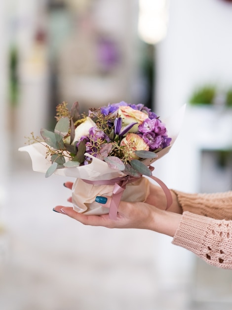 Entrega especial de ramo de flores para alguien que amas. Manos de mujeres sosteniendo un arreglo floral creativo