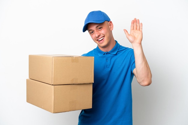 Entrega joven hombre brasileño aislado ops fondo blanco saludando con la mano con expresión feliz