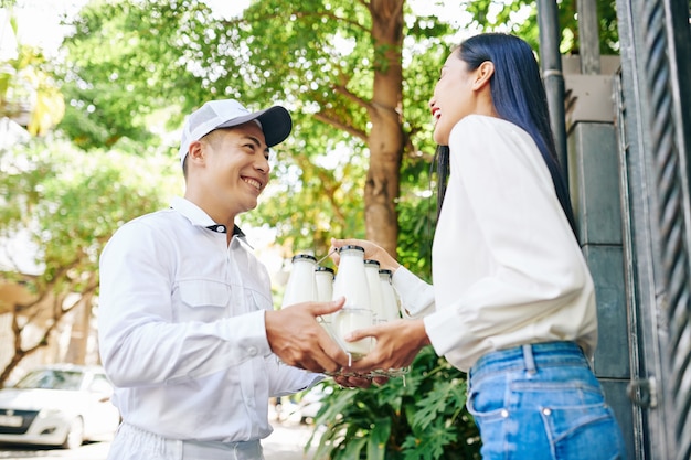 Entrega de leche a mujer joven