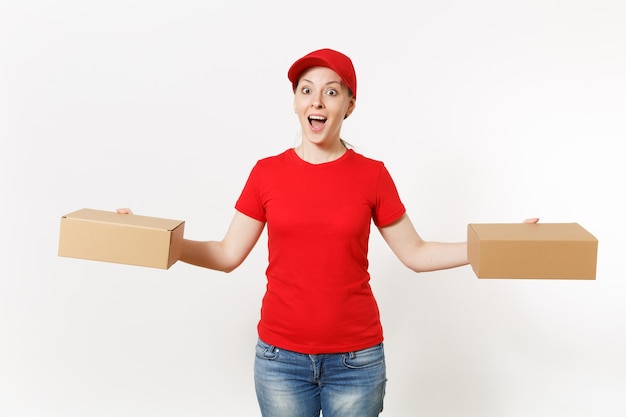 Entrega mulher sorridente em uniforme vermelho, isolado no fundo branco. Mulher de boné, camiseta, jeans trabalhando como mensageira ou traficante segurando caixas de papelão. Recebendo pacote. Copie o espaço para anúncio.