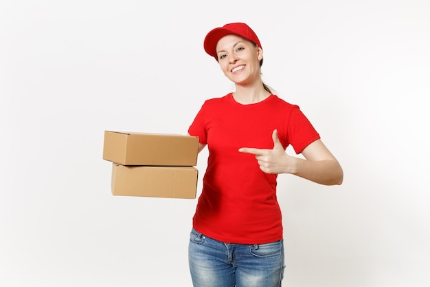 Entrega mulher sorridente em uniforme vermelho, isolado no fundo branco. Mulher de boné, camiseta, jeans trabalhando como mensageira ou traficante segurando caixas de papelão. Recebendo pacote. Copie o espaço para anúncio.