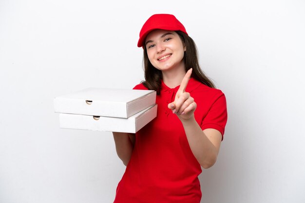 Entrega de pizza rusa joven recogiendo cajas de pizza aisladas de fondo blanco mostrando y levantando un dedo