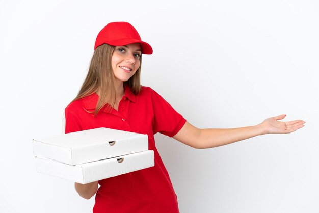 Entrega de pizzas mujer lituana aislada sobre fondo blanco extendiendo las manos hacia el lado para invitar a venir