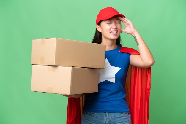 Entrega de superhéroe Mujer asiática sosteniendo cajas sobre un fondo aislado sonriendo mucho