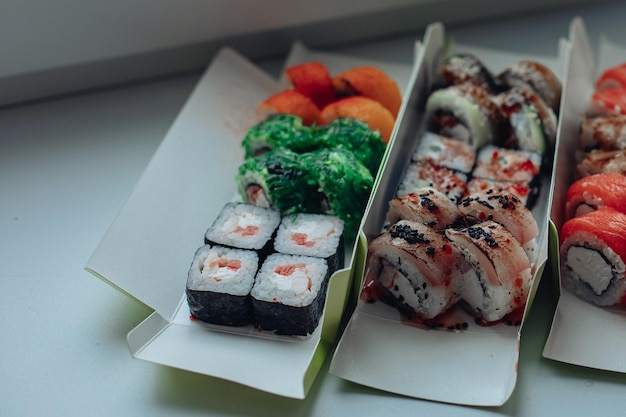 Foto entrega de sushi diferentes variedades de sushi para el almuerzo o la cena.