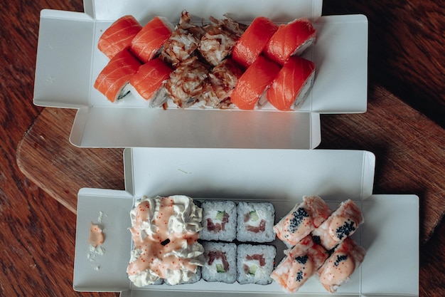 Foto entrega de sushi diferentes variedades de sushi para el almuerzo o la cena.