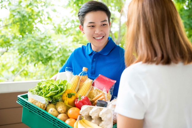 Entregador asiático entregando comida para um cliente em sua residência