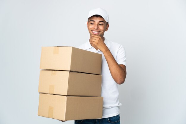 Entregador brasileiro isolado no fundo branco olhando para o lado e sorrindo