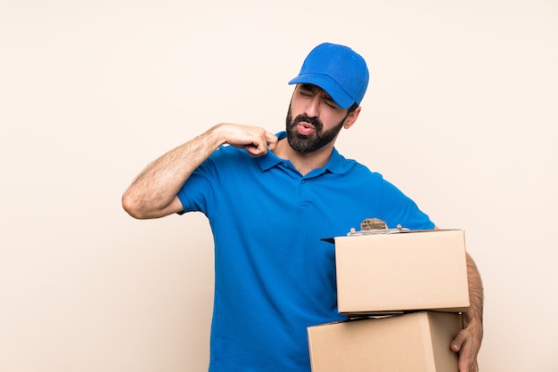 Entregador com barba sobre parede isolada com expressão cansada e doente