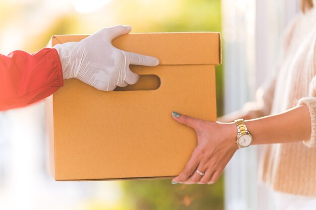 Foto entregador dando caixas para mulheres jovens em casa, conceito de serviço de correio