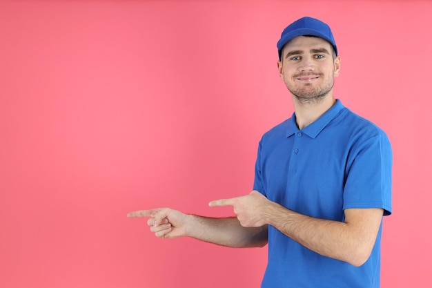 Foto entregador de boné e camiseta em fundo rosa