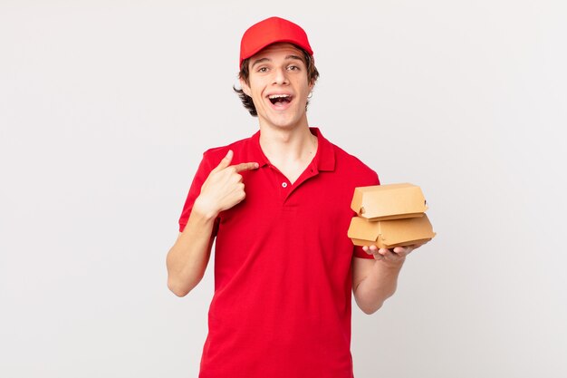Entregador de hambúrgueres sentindo-se feliz e apontando para si mesmo com uma empolgação