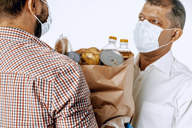 Entregador de máscara facial e luvas. entrega de comida, conceito de compra online enquanto pandemia de coronavírus em todo o mundo