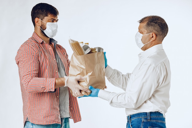 Foto entregador de máscara facial e luvas. entrega de comida, conceito de compras on-line enquanto pandemia de coronavírus