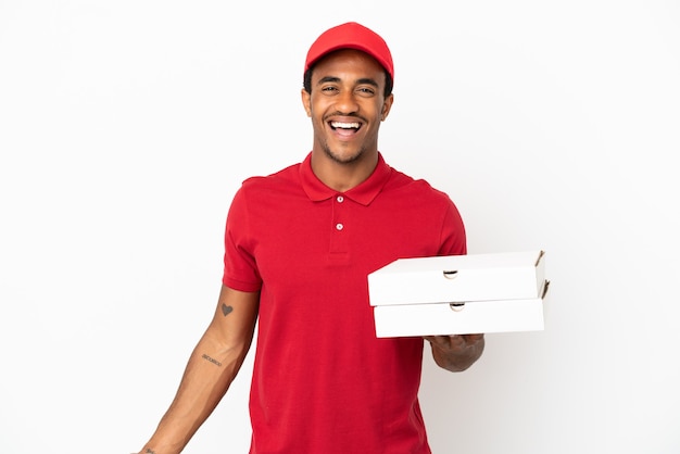 Entregador de pizza afro-americano pegando caixas de pizza na parede branca isolada sorrindo muito