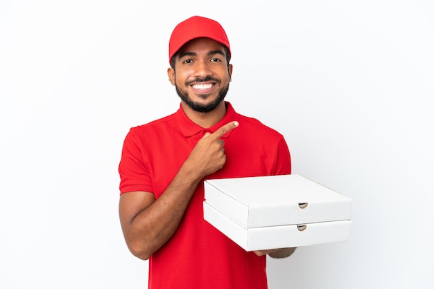 Entregador de pizza pegando caixas de pizza isoladas no fundo branco apontando para o lado para apresentar um produto
