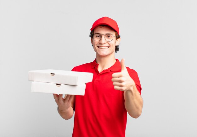 Entregador de pizza sentindo-se orgulhoso, despreocupado, confiante e feliz, sorrindo positivamente com o polegar para cima