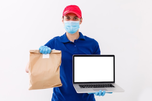 Entregador em luvas de máscara de uniforme de t-shirt em branco de tampa vermelha isoladas no fundo branco, trabalho de funcionário de cara segura computador portátil, vírus coronavírus pandêmico de quarentena de serviço conceito de 2019-ncov