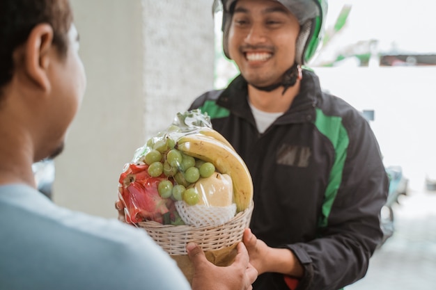 Entregador, entregando frutas parcela