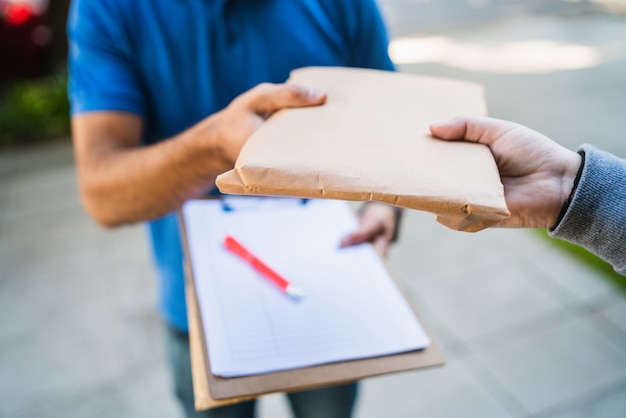 Entregador fazendo entrega em domicílio ao cliente