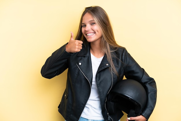 Foto entregador jovem sobre parede amarela isolada sorrindo e mostrando sinal de vitória