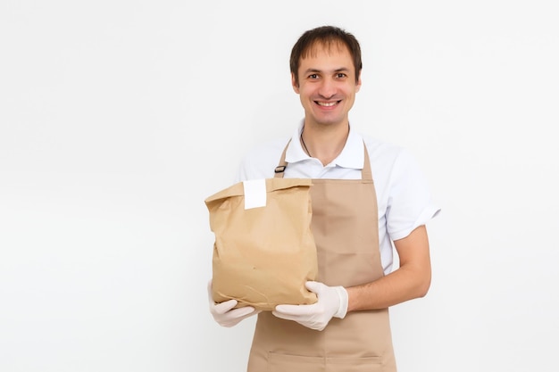 entregador trabalhando em camisa com avental e luvas de proteção mão segurando um pacote isolado com fundo branco