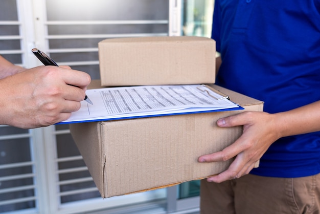 Entregador verificando ou segurando o pacote de papelão