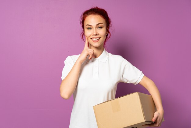 Entregadora de adolescente na parede roxa, sorrindo com uma expressão feliz e agradável