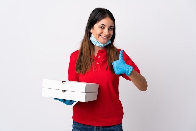 Entregadora de pizza segurando uma pizza isolada no branco com o polegar para cima porque algo bom aconteceu