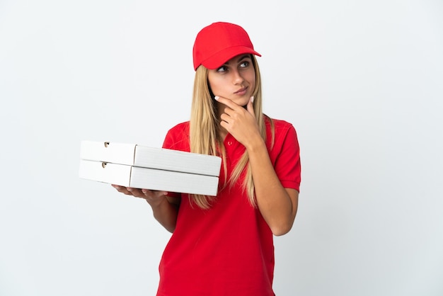 Entregadora de pizza segurando uma pizza isolada no espaço em branco com dúvidas