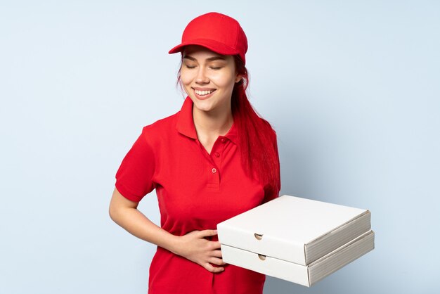 Entregadora de pizza, segurando uma pizza sobre fundo isolado, sorrindo muito