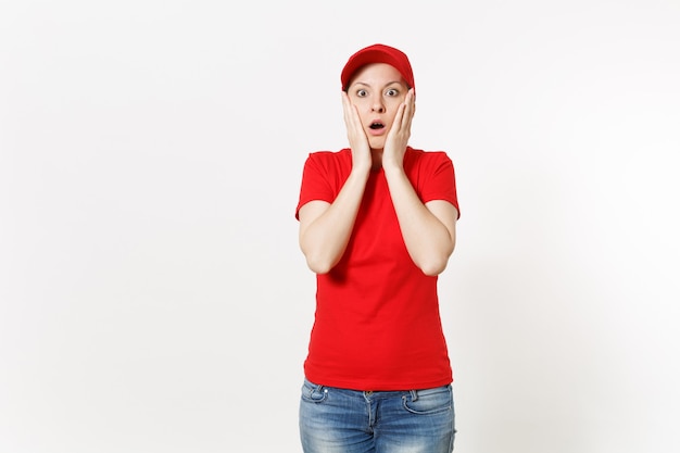 Entregadora de uniforme vermelho, isolado no fundo branco. mulher profissional chocada com boné, camiseta, jeans, trabalhando como mensageiro ou revendedor, de mãos dadas perto do gesto de rosto. copie o espaço, anúncio.