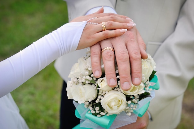 Entregue a la novia y el novio con anillos en el ramo de la boda