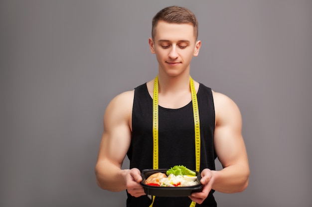 El entrenador consume una comida rica en proteínas de carne y fruta