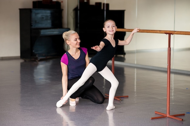 El entrenador le enseña a la niña cómo estirar la coreografía